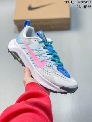 White Nike trail running shoe with blue and pink accents and a contrasting outsole.