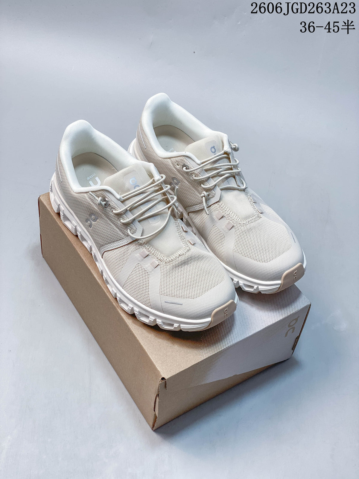 Pair of light ivory On Cloudtilt Remix sneakers displayed on a shoebox