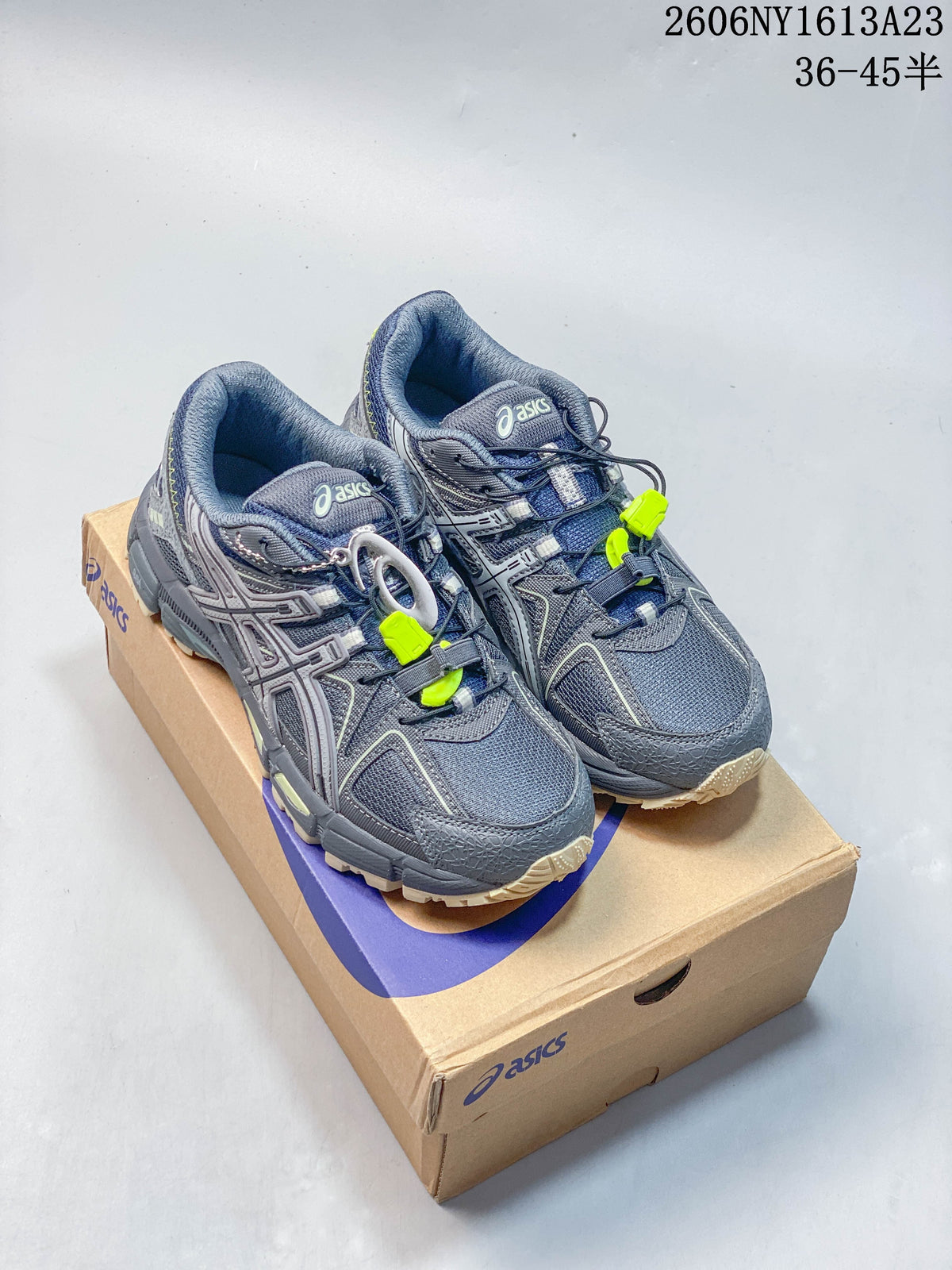 Pair of grey ASICS Gel-Kahana 8 FL sneakers with navy and lime accents, shown on a shoebox