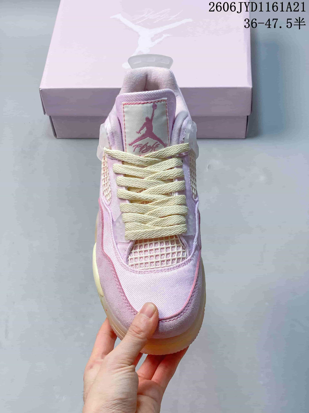 Front view of a pink Jordan sneaker with cream laces and mesh panels.