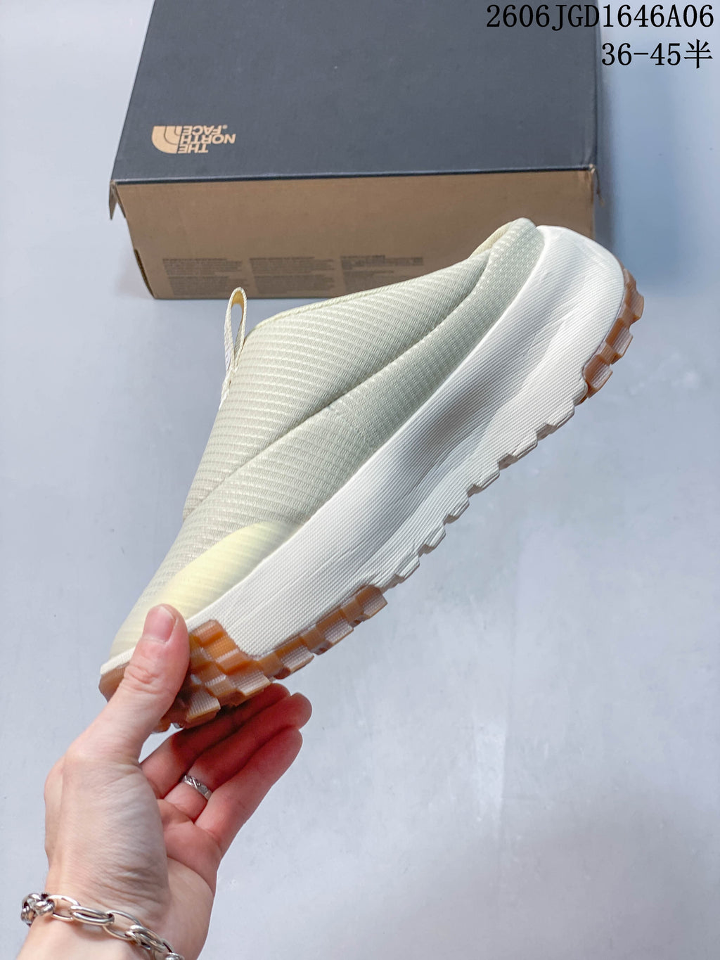 Side profile of the cream slip-on mule with a raised tread outsole