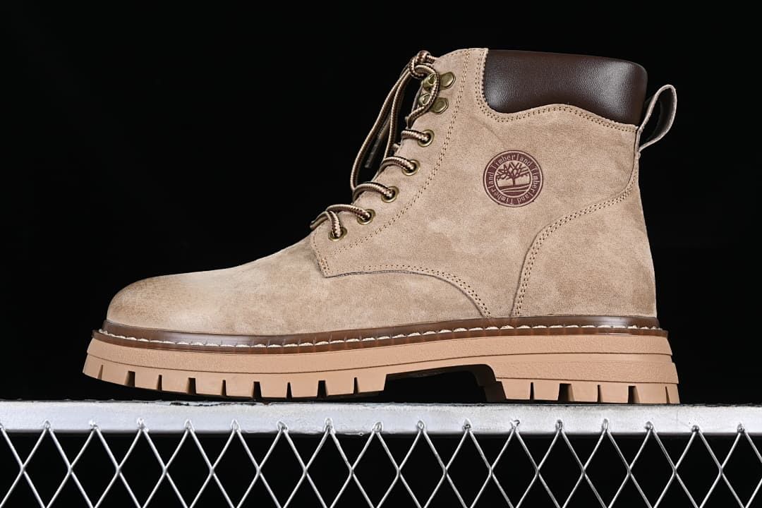 Side view of the khaki boot showing its lace-up design, side emblem, and chunky sole.