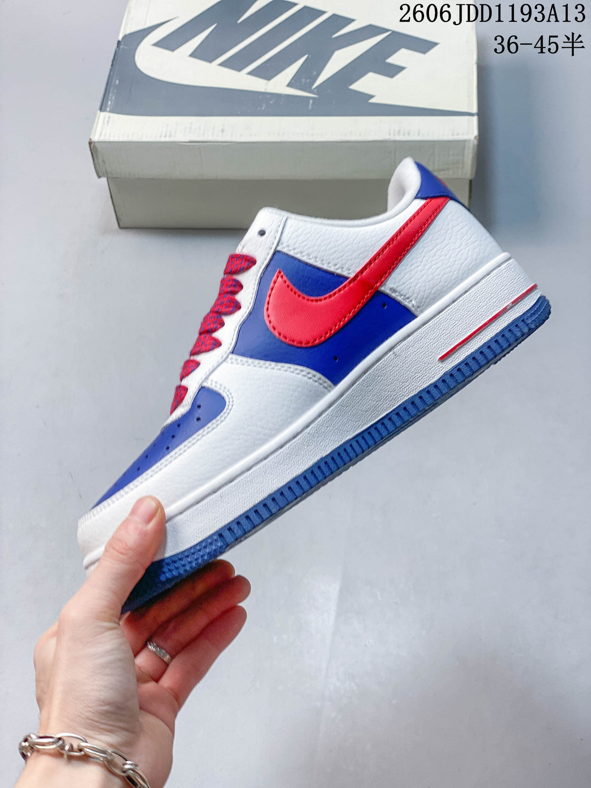 Side view of the low-top sneaker with red Swoosh and blue panels