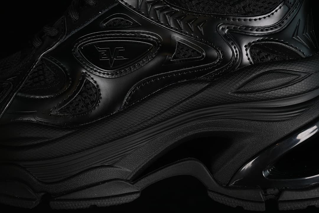 Close-up of the black sneaker's layered side panels and chunky sole.