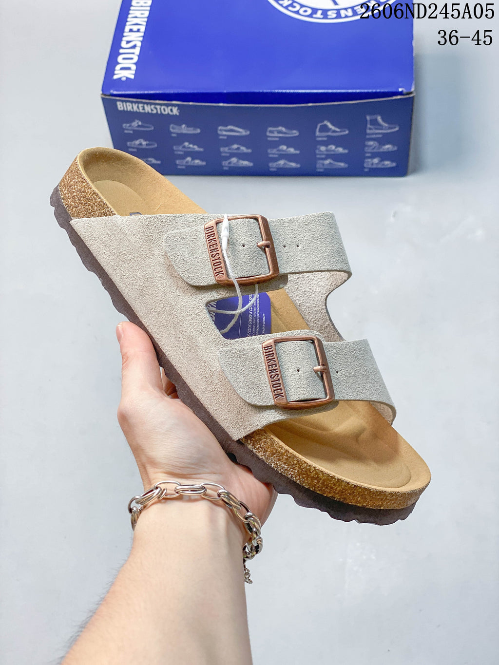 Light gray two-strap sandal with contoured footbed and textured outsole.