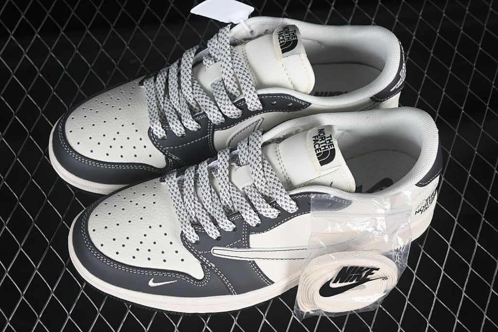 Pair of off-white and dark gray low-top sneakers shown from above, with perforated toe panels and an extra lace set.