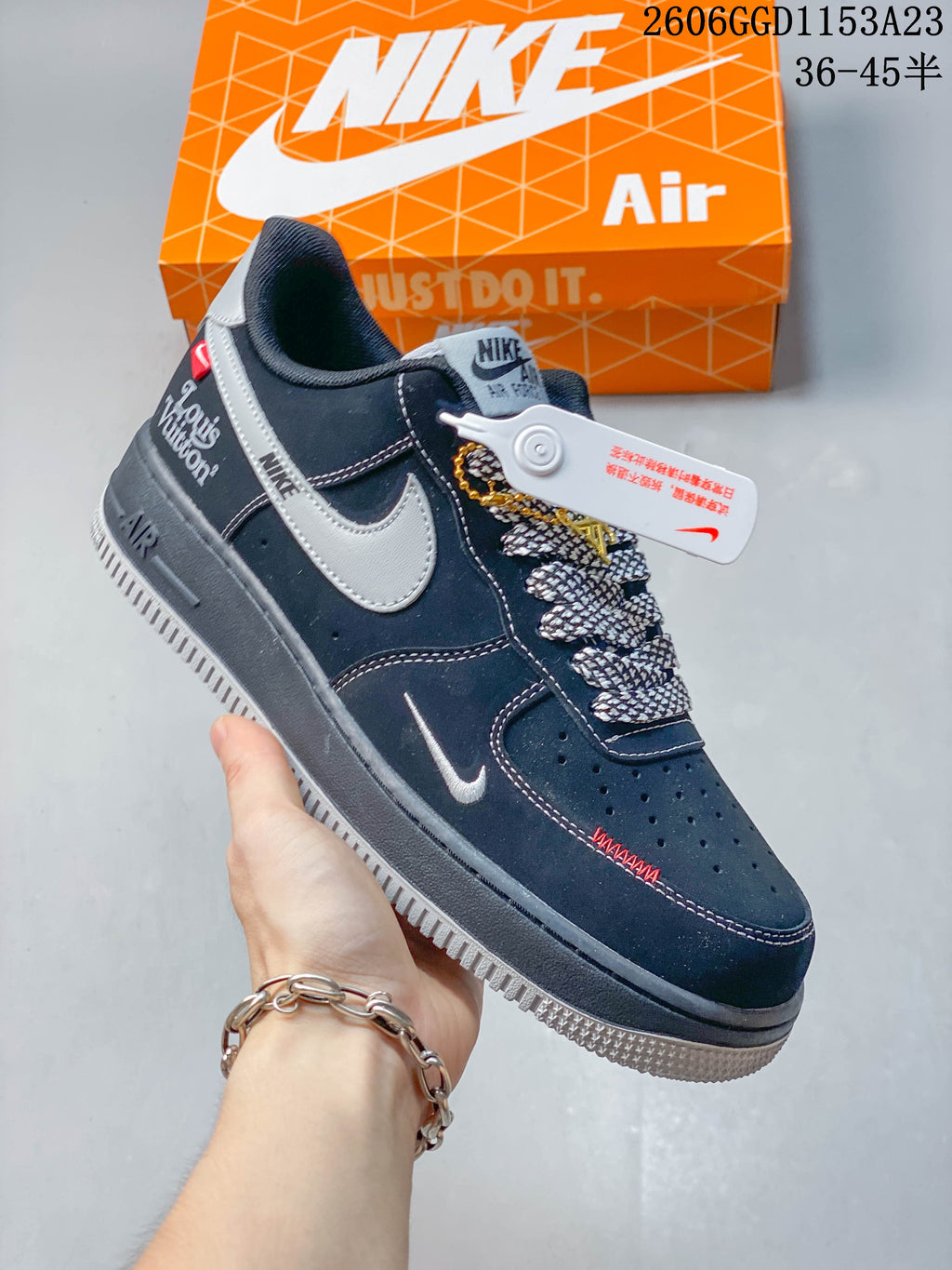 Angled view of the sneaker showing gray side panels, small red details, and decorative accents