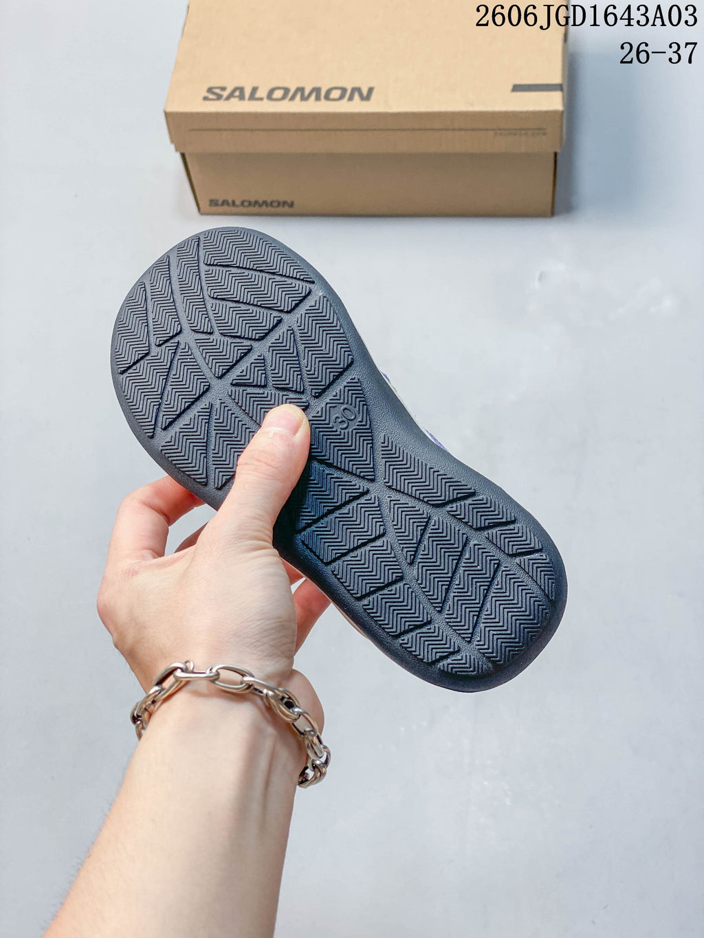 Close-up of the patterned dark outsole on a Salomon kids' sneaker