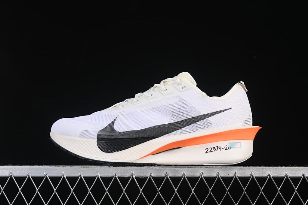 Nike ZoomX Vaporfly 4 road racing shoe in white with black Swoosh and orange midsole accent, side view