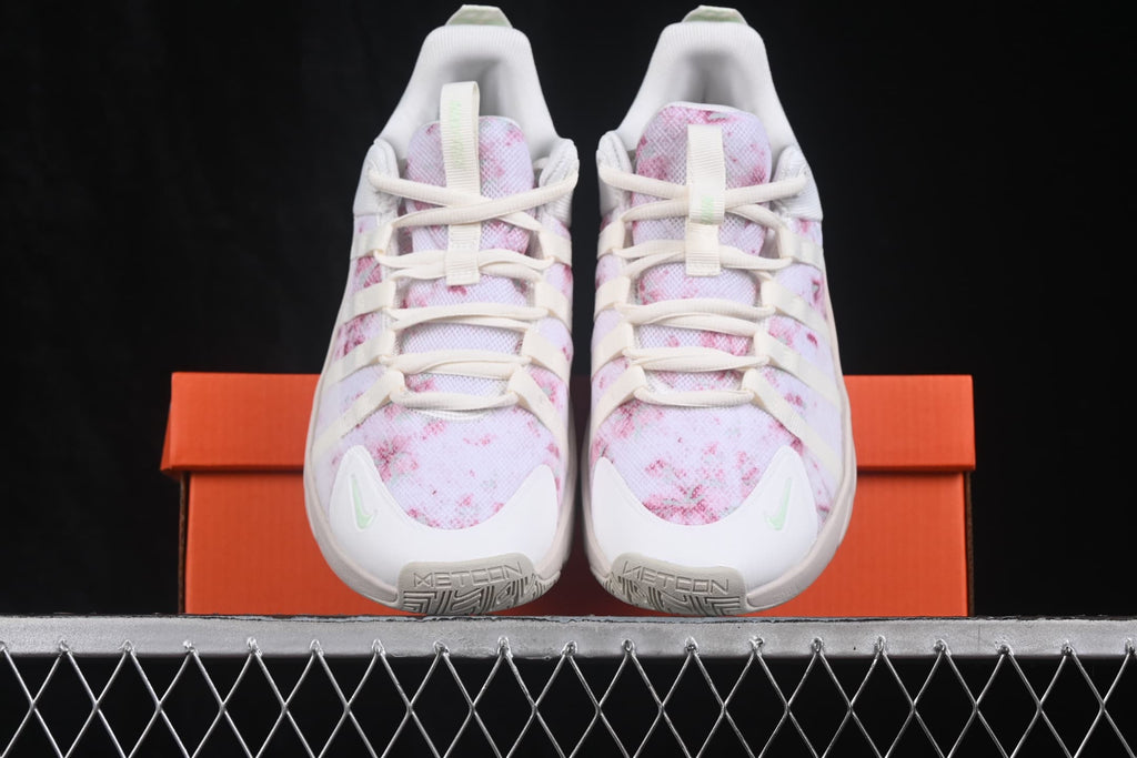 Pair of Nike Free Metcon 7 sneakers viewed from the front, showing white uppers with pink patterned panels and light mint accents.