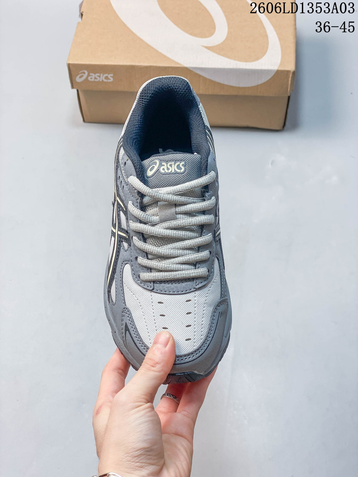 Top view of the laces and perforated toe panel on the grey sneaker.
