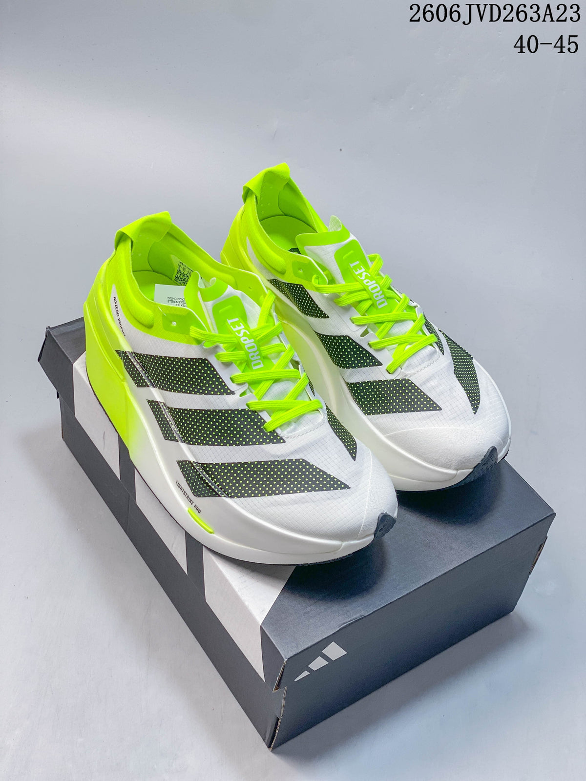 Pair of white Adidas Adizero Dropset Elite shoes with dark side graphics and neon-yellow accents, shown on a shoebox.