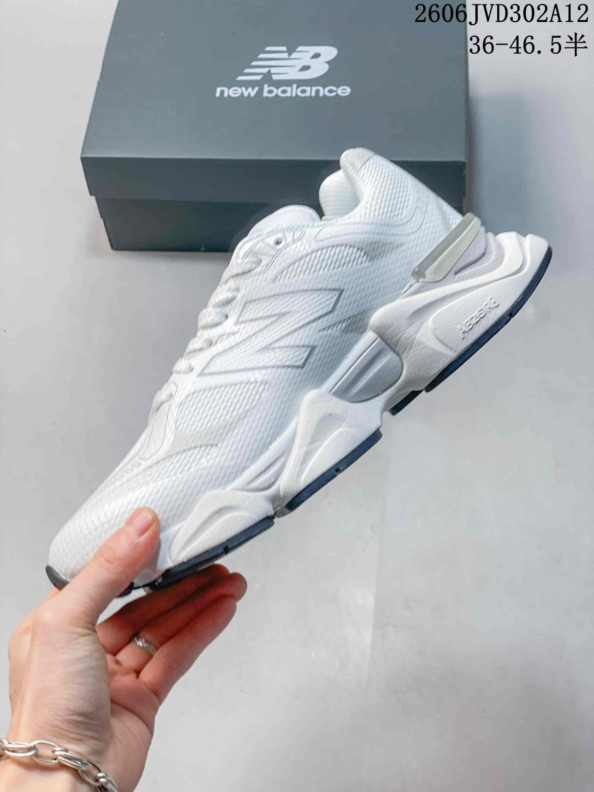 Side view of the white sneaker with layered panels, mesh-textured areas, and a sculpted sole.