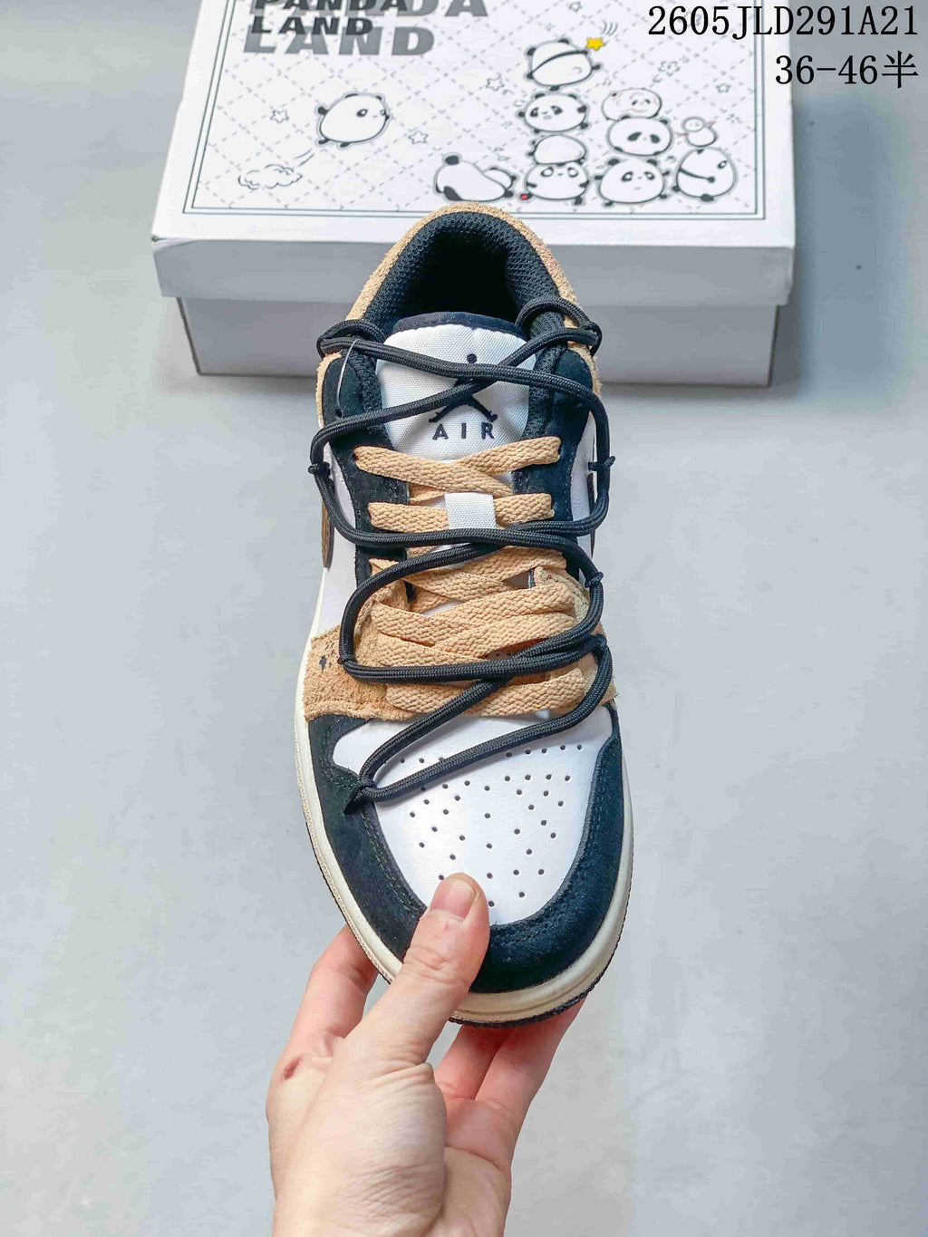 Top view showing perforated toe, layered tan laces, and dark overlays