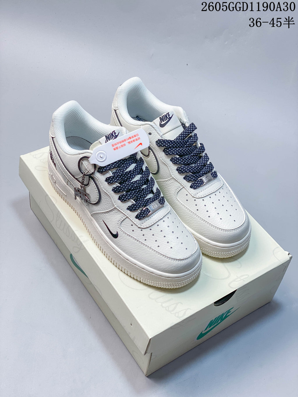 Pair of white Nike Air Force 1 ’07 LV8 low-top sneakers with dark patterned laces on a shoebox