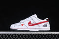 Side view of a white low-top sneaker with red and black graphic details and a dark outsole.