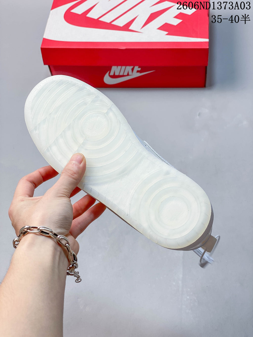 Underside of the sneaker showing a white outsole with circular tread patterns