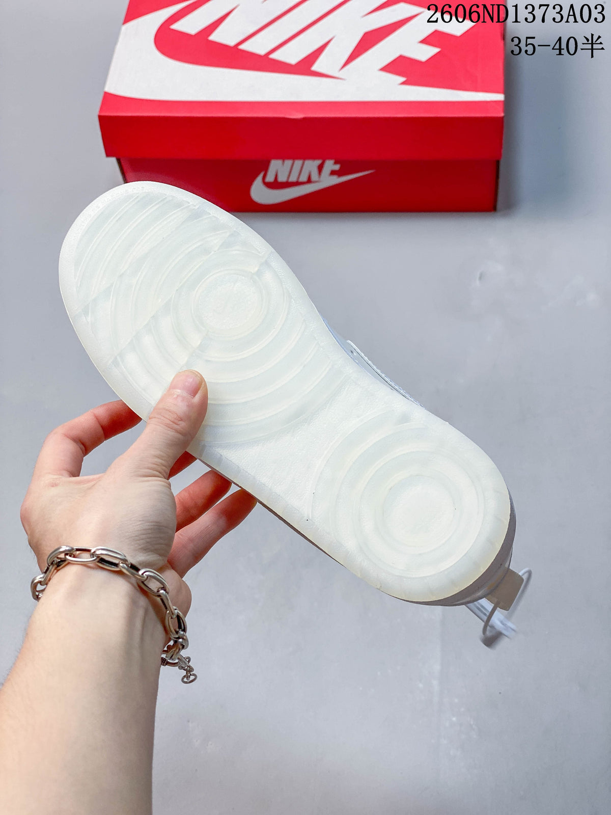 Underside of the sneaker showing a white outsole with circular tread patterns