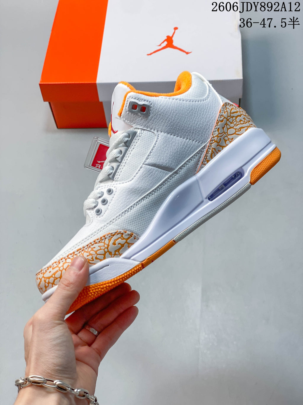 Side profile showing the white upper, patterned overlays, and visible midsole window.