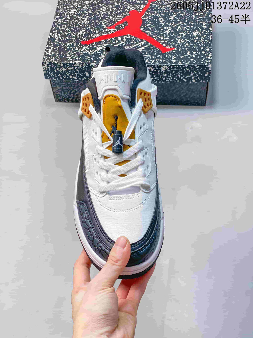Top view of the sneaker showing white laces and a gold tongue panel