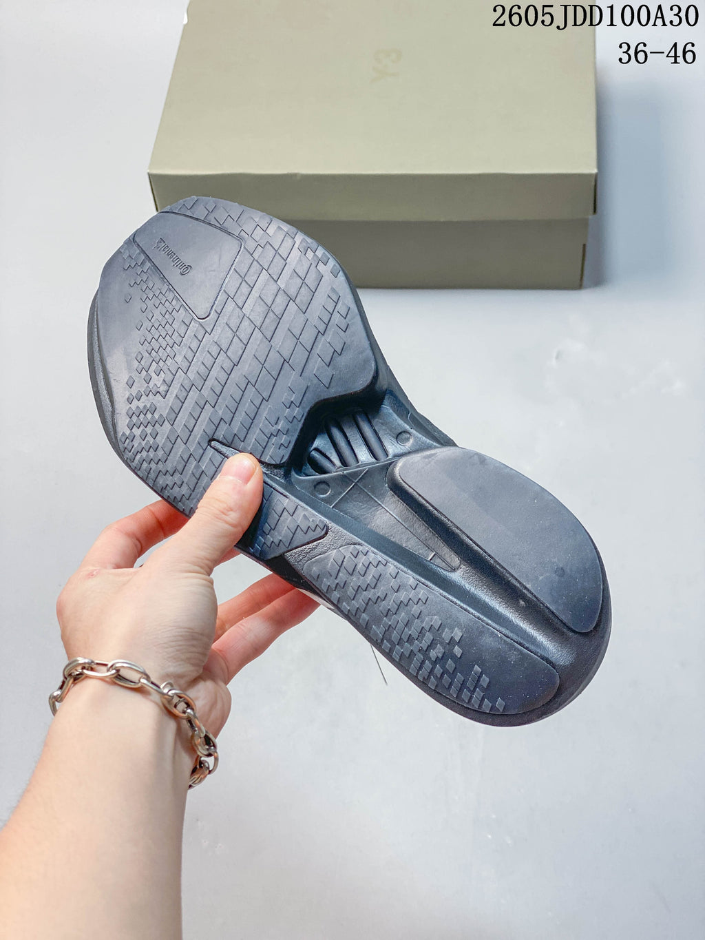 Underside of a gray running shoe showing its textured outsole