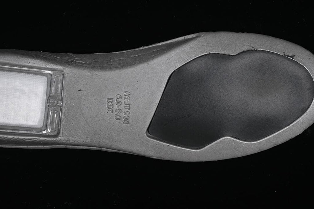Underside view showing the shoe outsole and molded markings