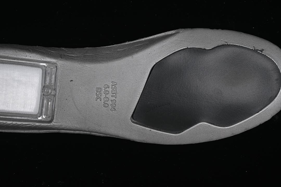 Underside view showing the shoe outsole and molded markings