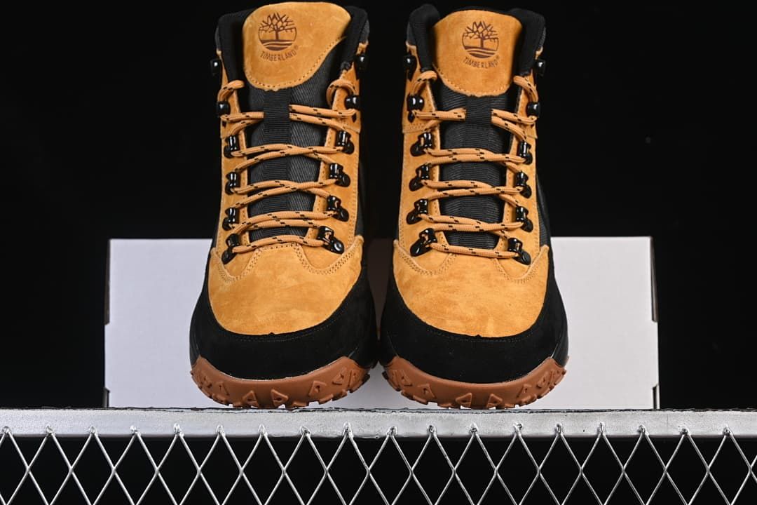 Front view of the pair of wheat and black lace-up boots