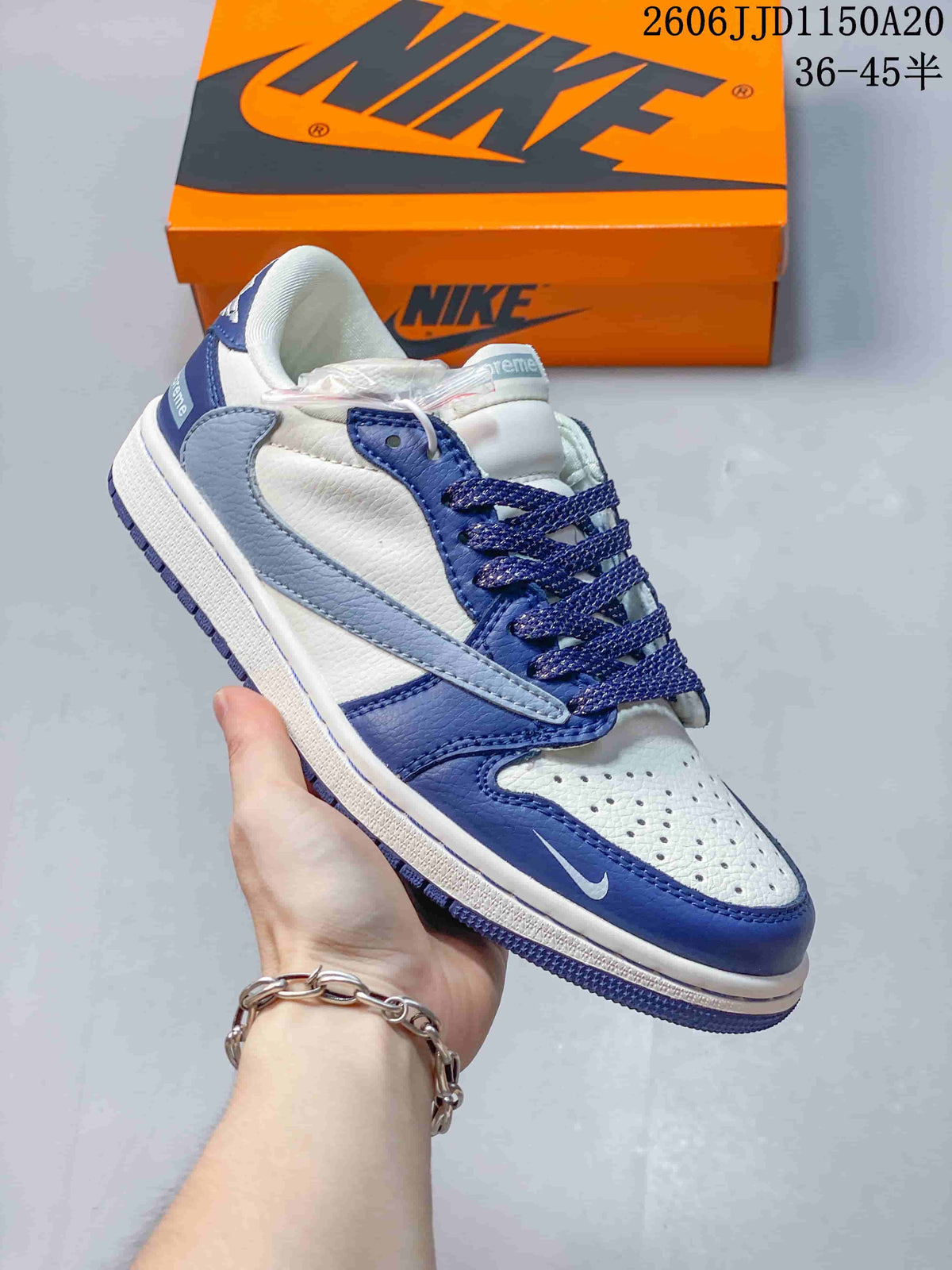 Close view of a blue and white low-top sneaker with contrasting overlays and a pale blue side panel.