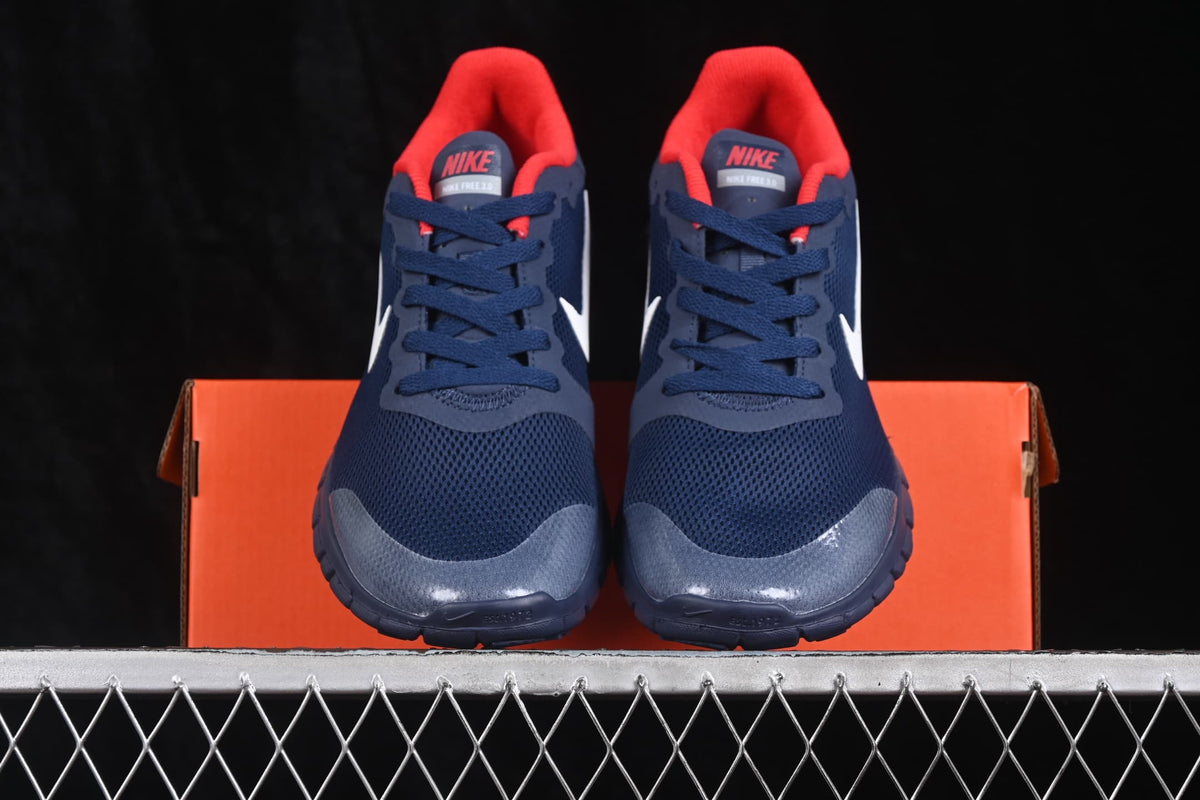 Front view of navy Nike Free 3.0 shoes with red collars, white Swoosh branding, and an orange shoe box.
