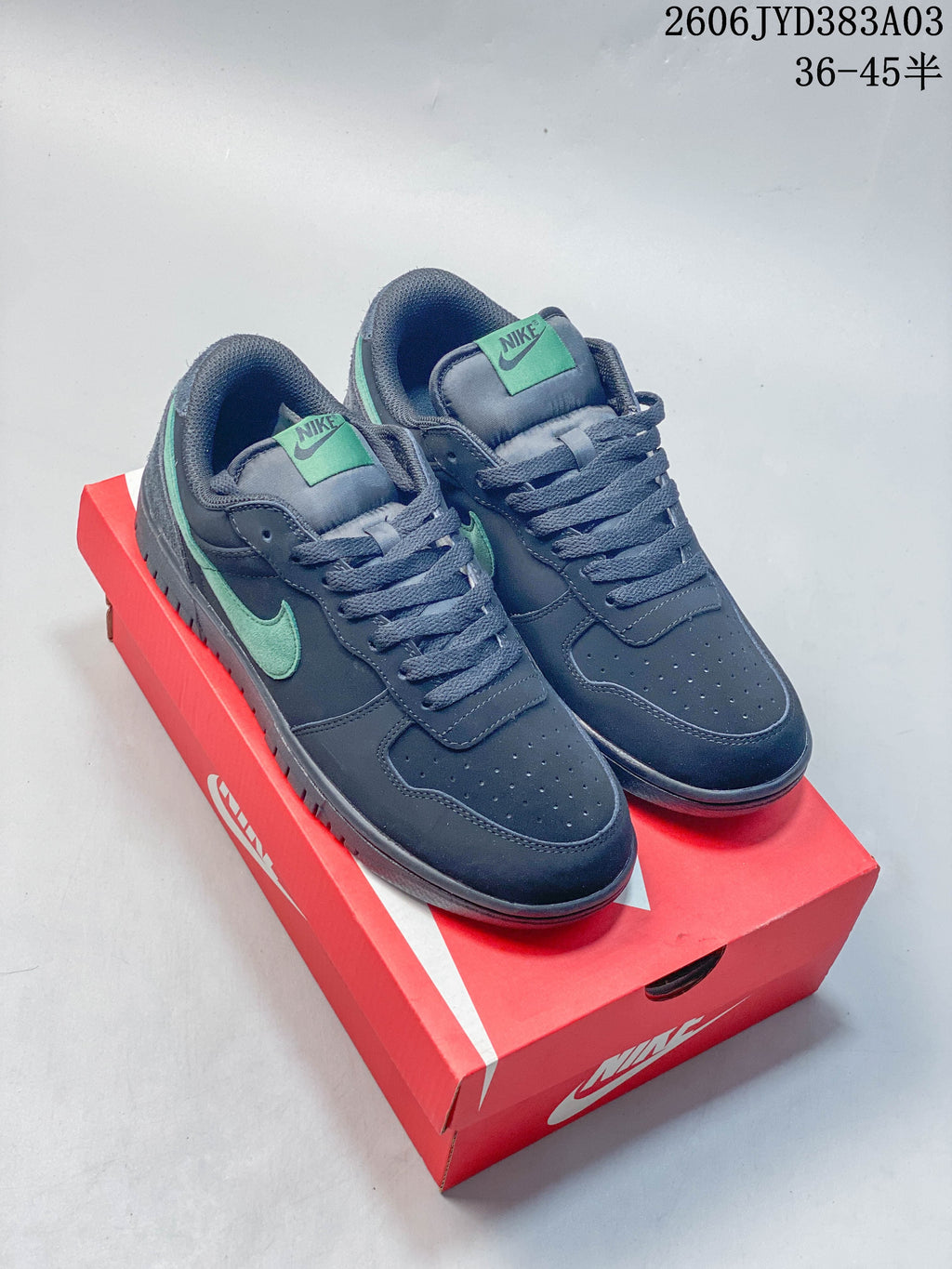 Pair of navy Nike Big Low low-top sneakers with mint accents, shown on a red shoe box