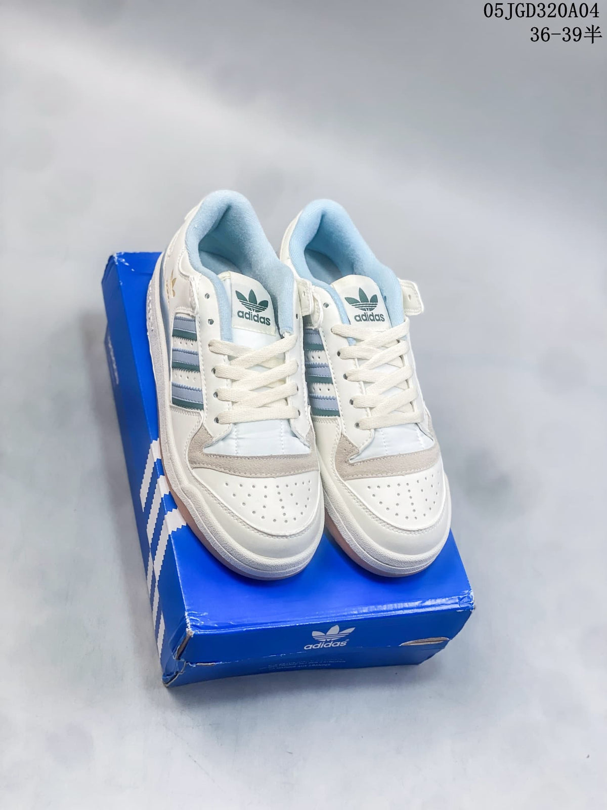 Pair of white Adidas Forum 84 Low sneakers with blue accents shown from the front