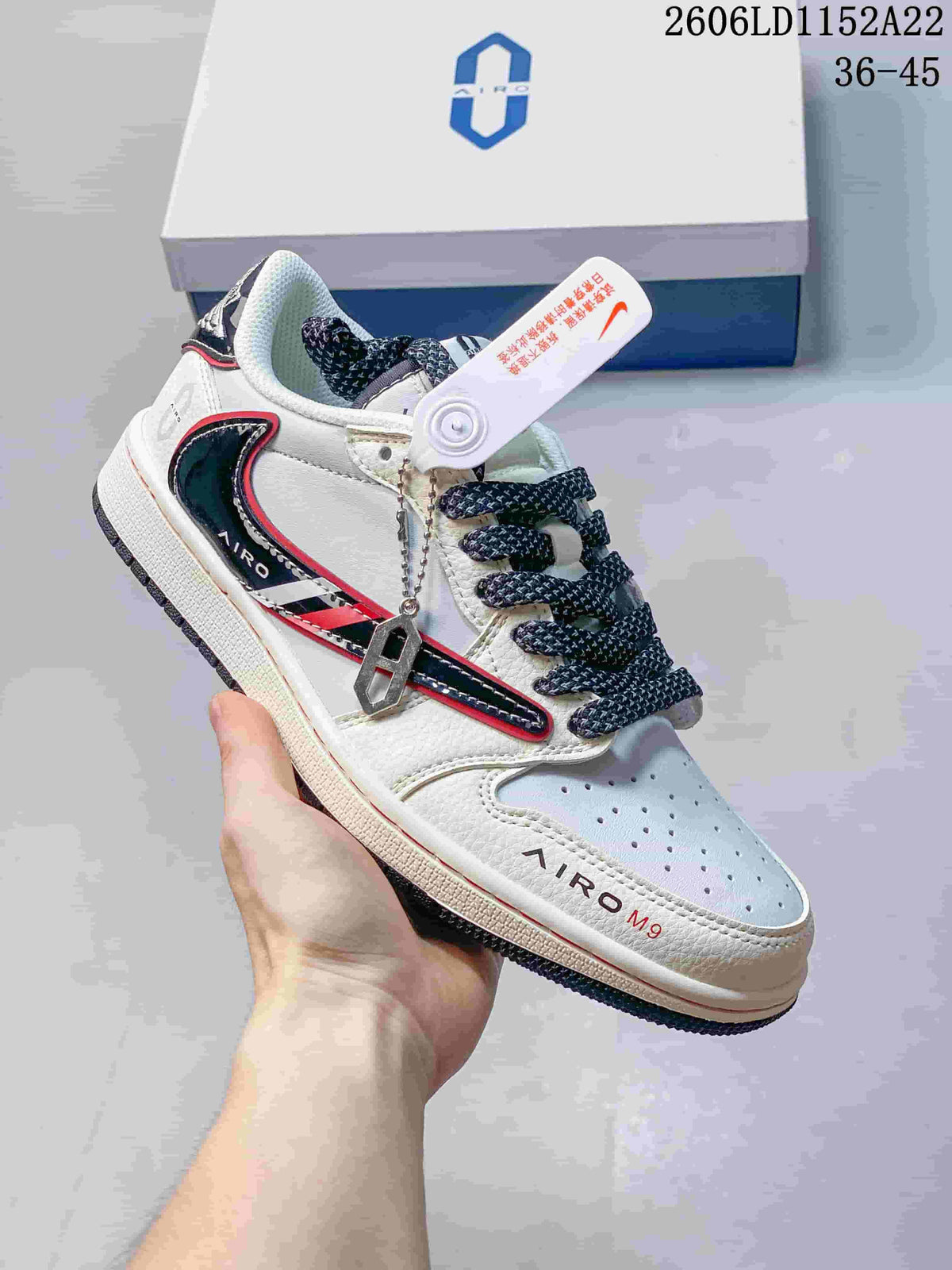 White low-top sneaker with black and red accents, patterned laces, and a hanging tag; size range 36–45 is printed in the image.