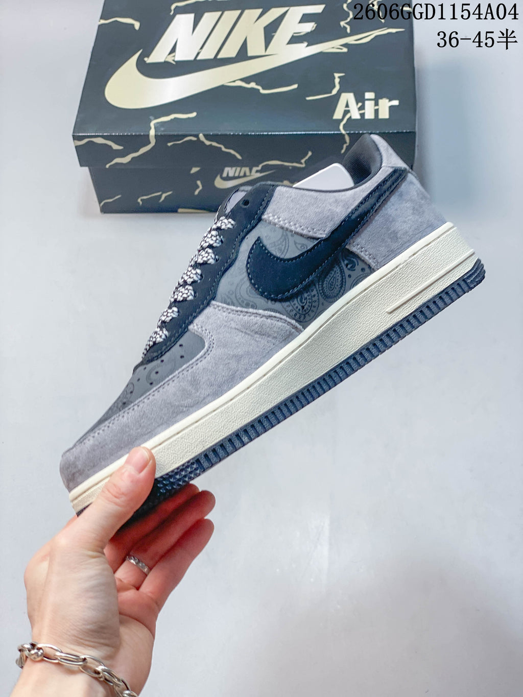 Side view of the sneaker with paisley panels, navy overlays, and grey accents