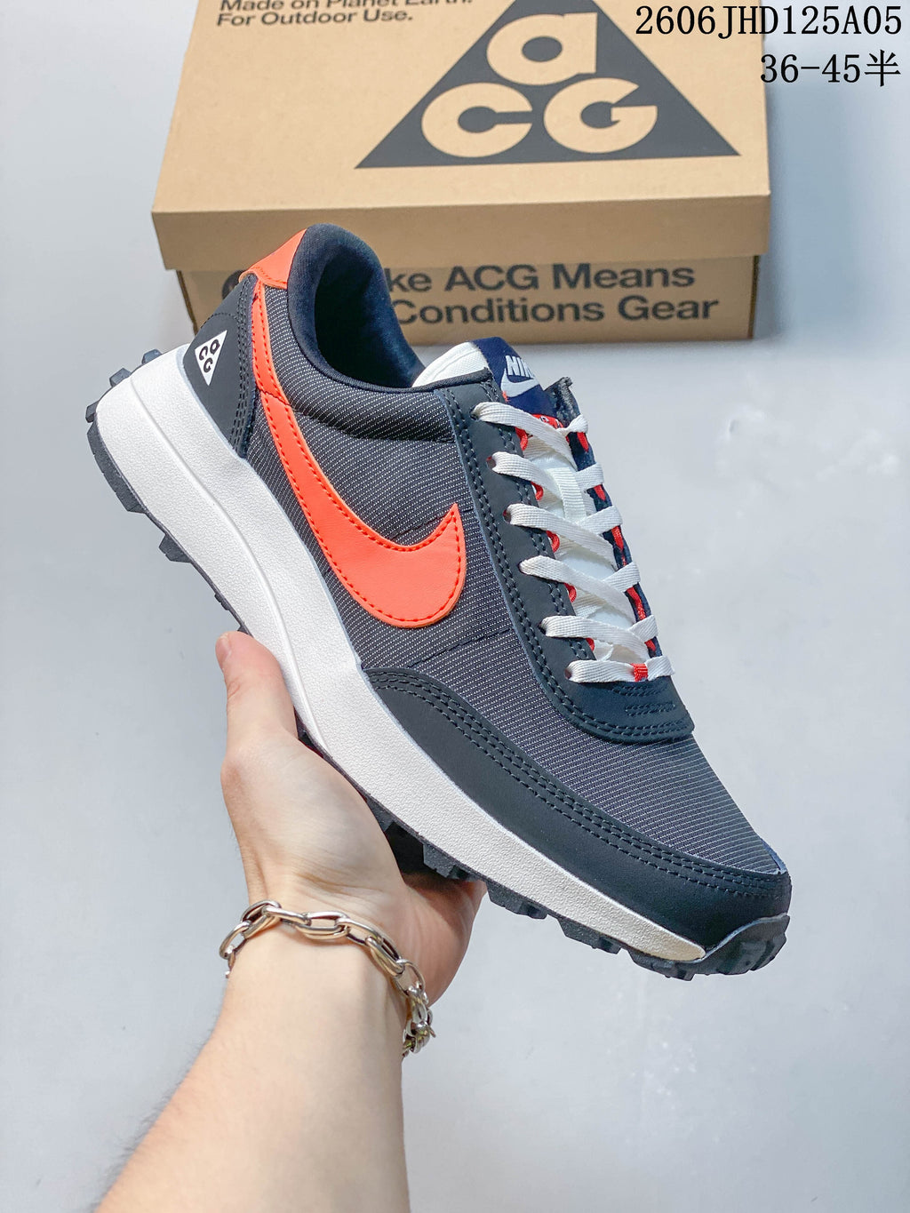 Side view of charcoal and orange Nike ACG LDV sneaker with a lugged outsole