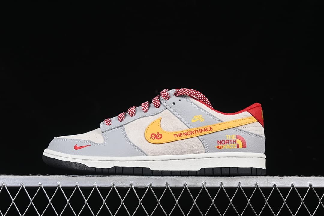 Side profile showing the shoe's gray and off-white color blocking and red accents