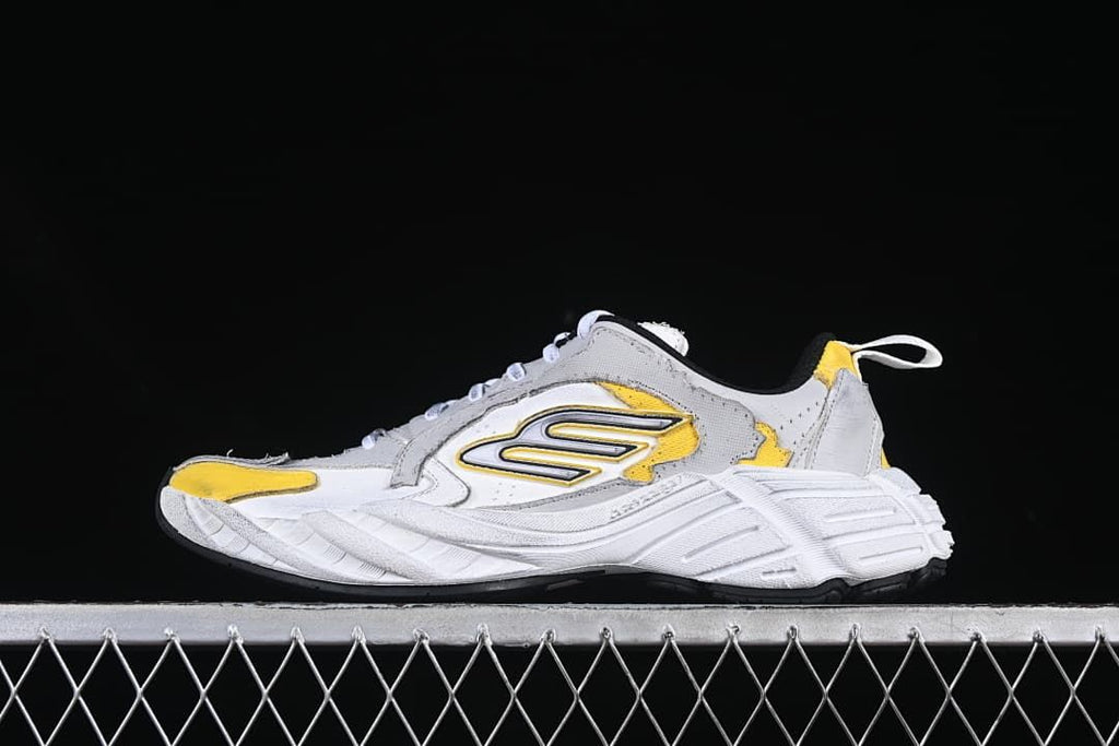 Side view of a grey, white and yellow low-top sneaker