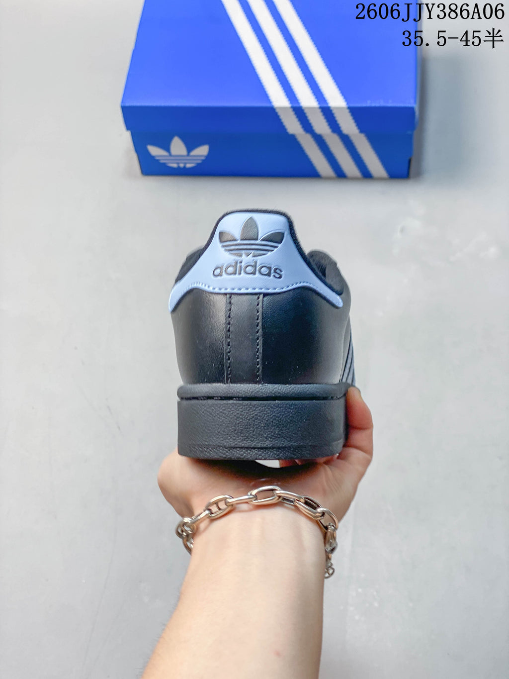 Rear view showing the pale blue heel detail on an adidas Superstar 2 sneaker