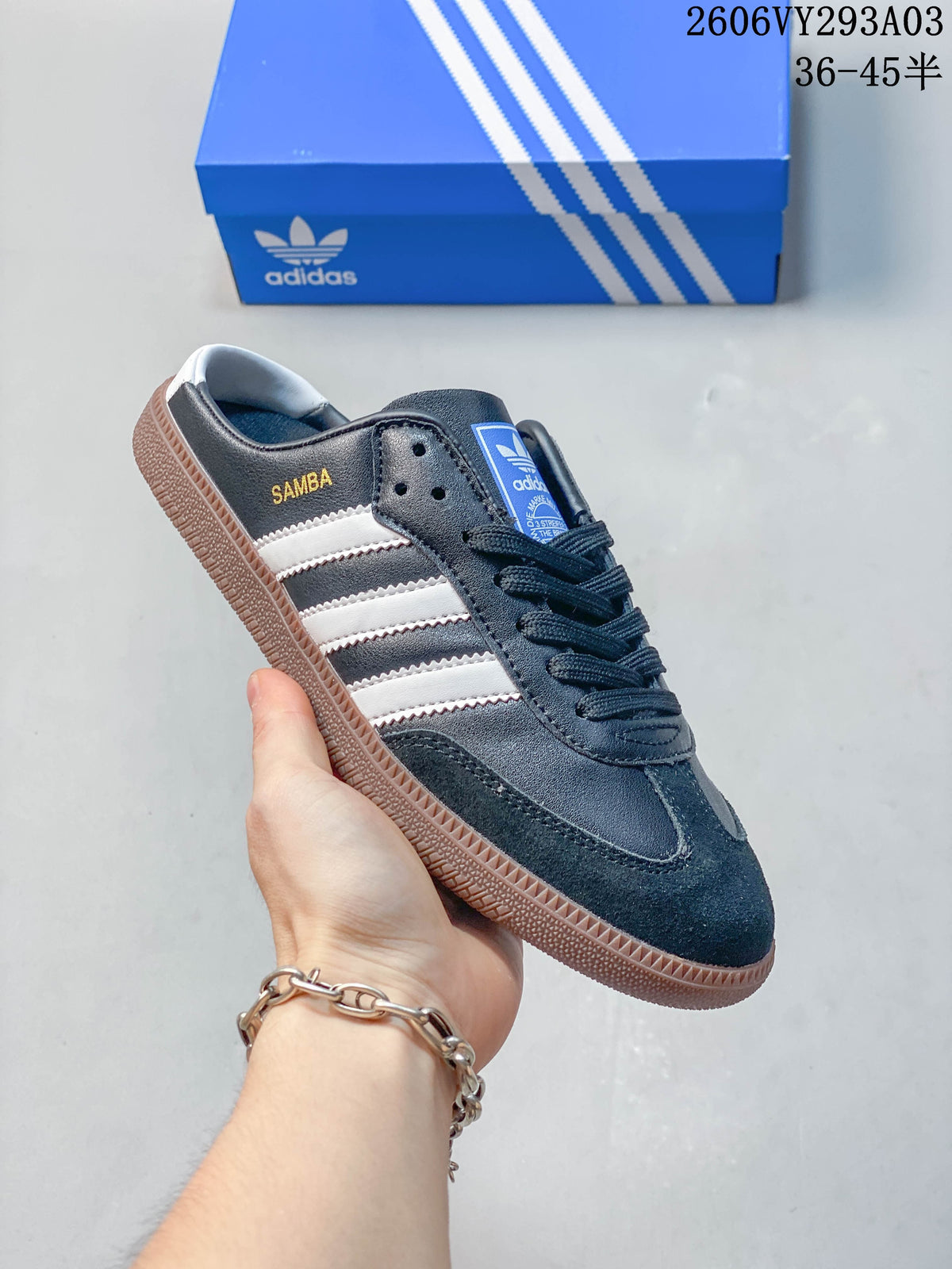 Side view of a navy Adidas Samba-branded sneaker with white stripes and a gum-colored sole.