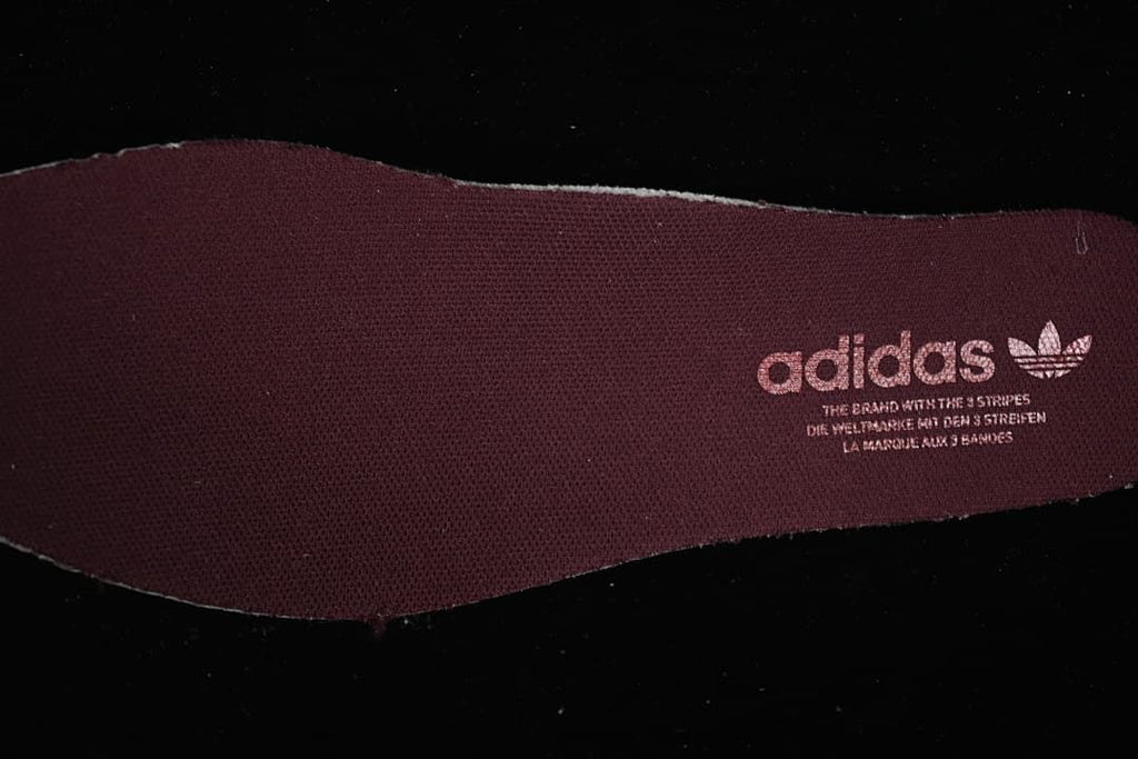 Burgundy insole with Adidas Trefoil branding.