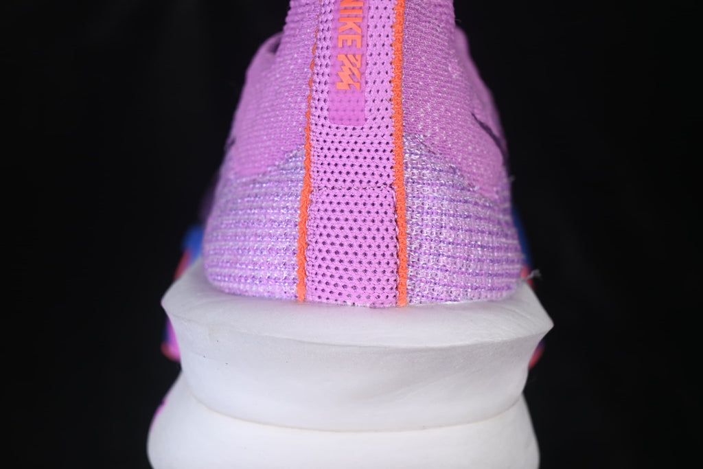Rear view of the purple shoe showing the heel pull tab and sculpted white sole.