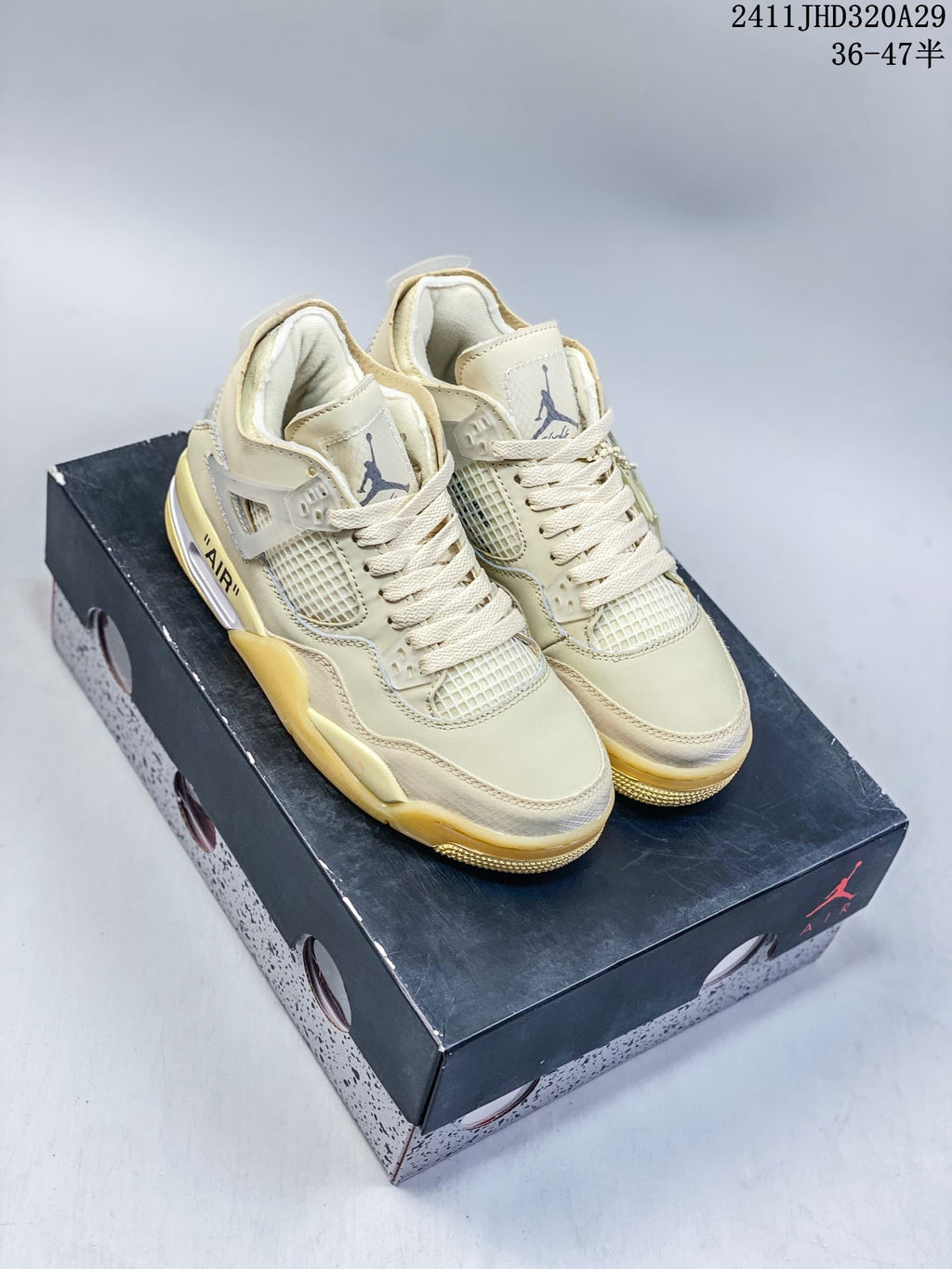 Pair of light sail-toned Air Jordan 4 Retro OG mid-top sneakers with pale yellow accents, displayed on a shoebox.