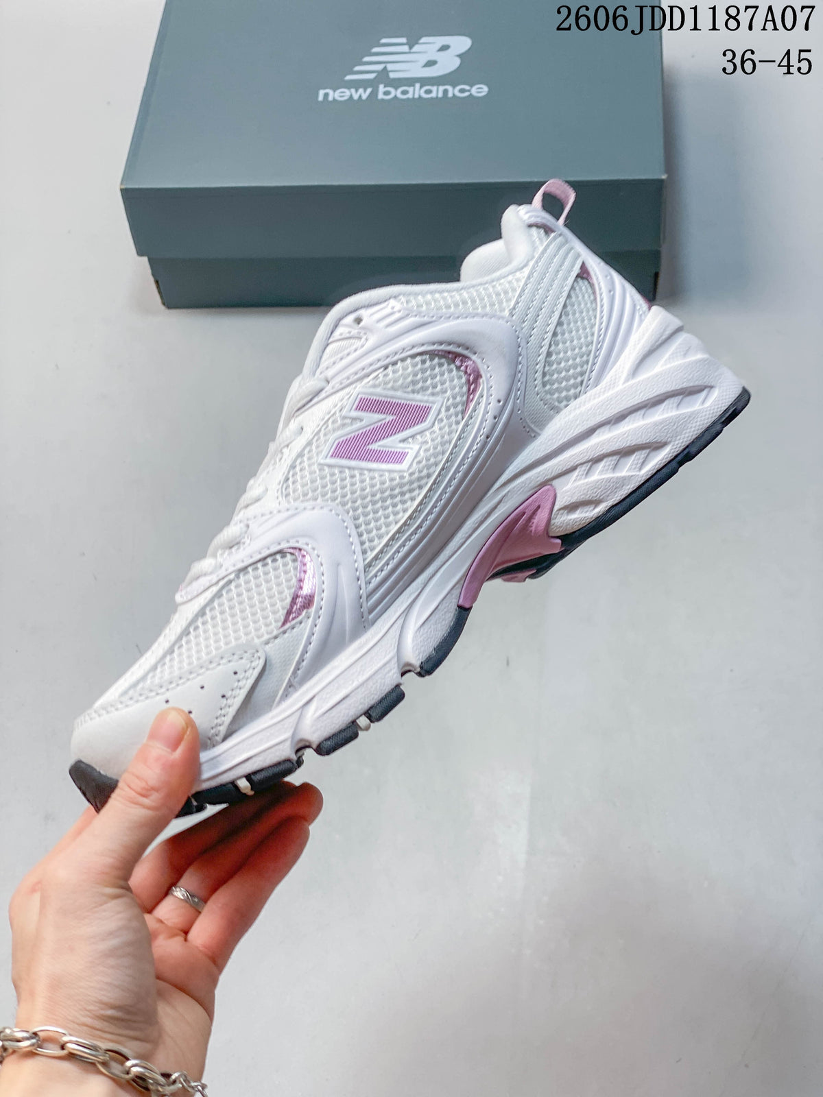 Side profile of a white and pink New Balance 530 sneaker