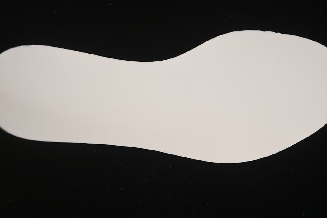 Light-colored shoe insole shown against a dark background