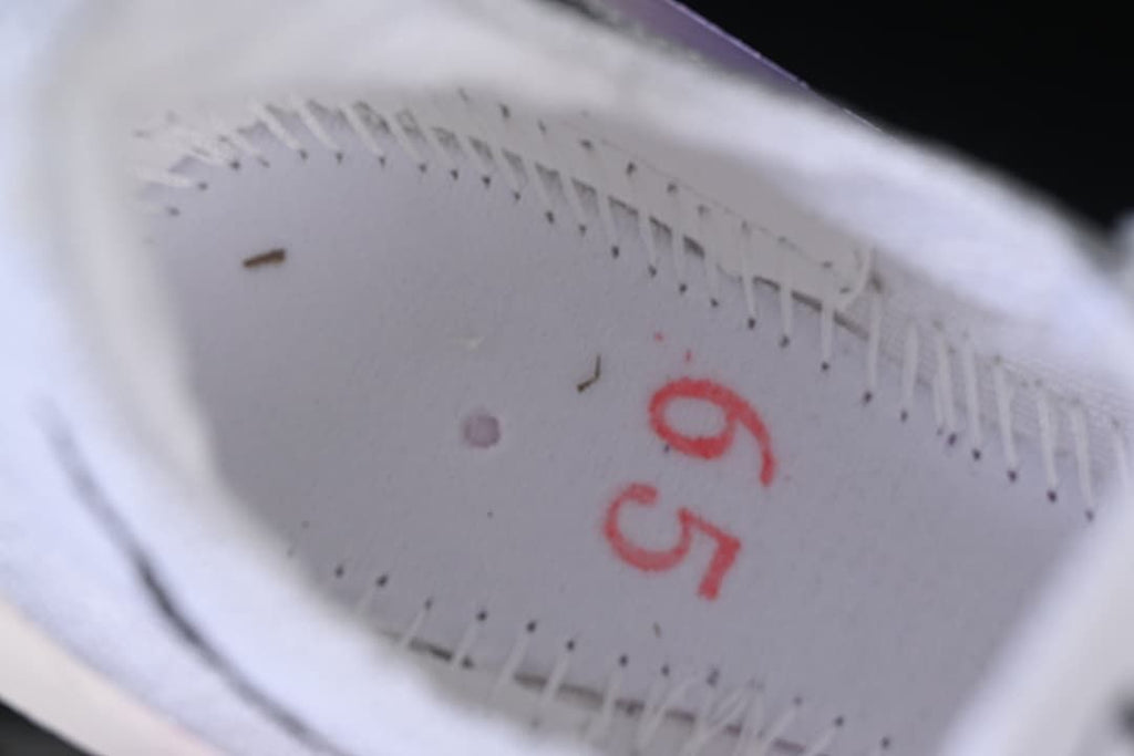 Close-up inside the shoe showing a red handwritten marking.