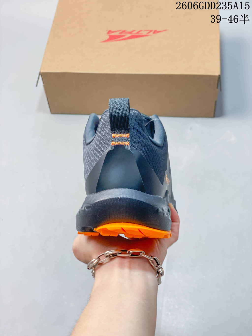 Rear view of the gray trail shoe with orange outsole details.