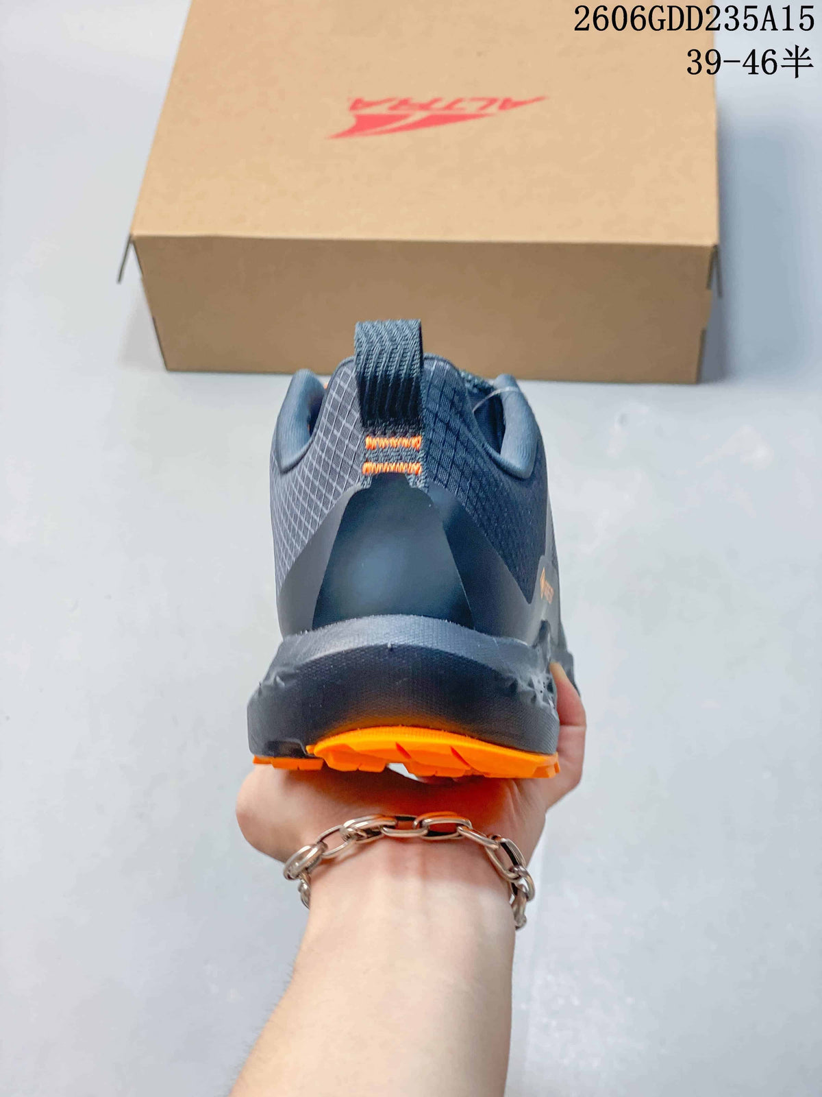 Rear view of the gray trail shoe with orange outsole details.