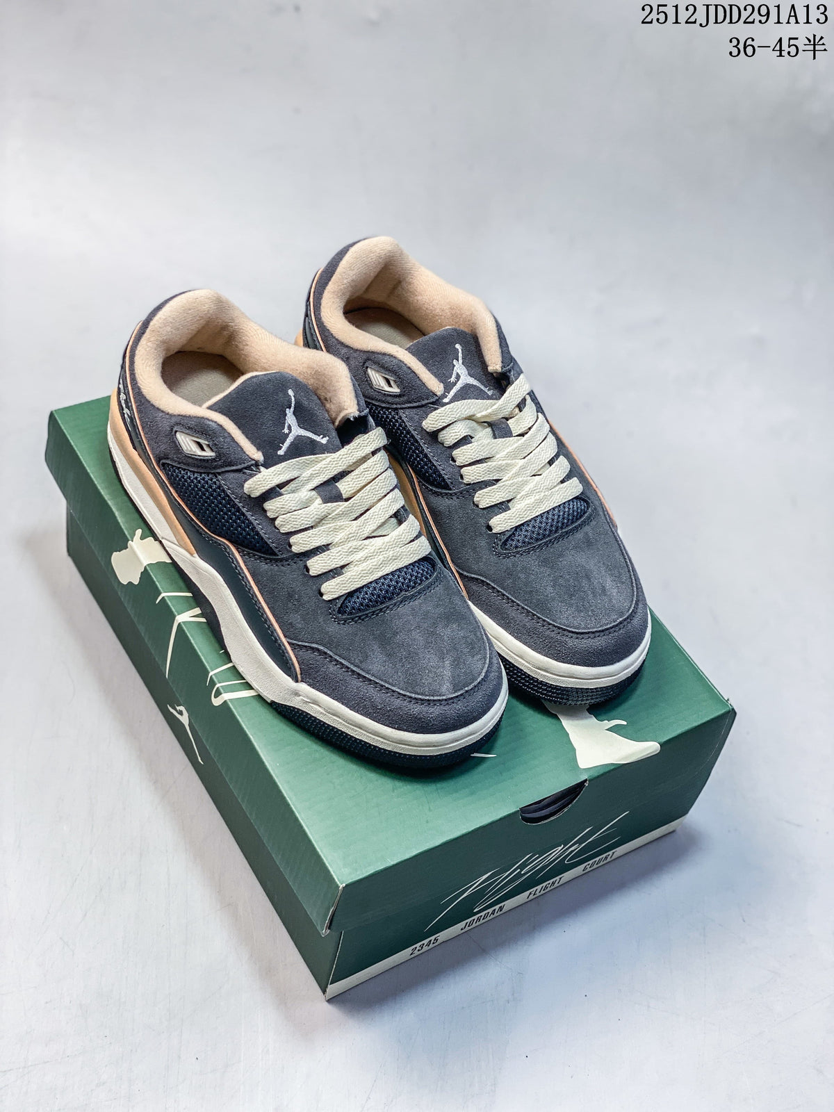 Pair of charcoal and navy Jordan Flight Court ATE low-top sneakers with cream laces and tan accents, displayed on a green box