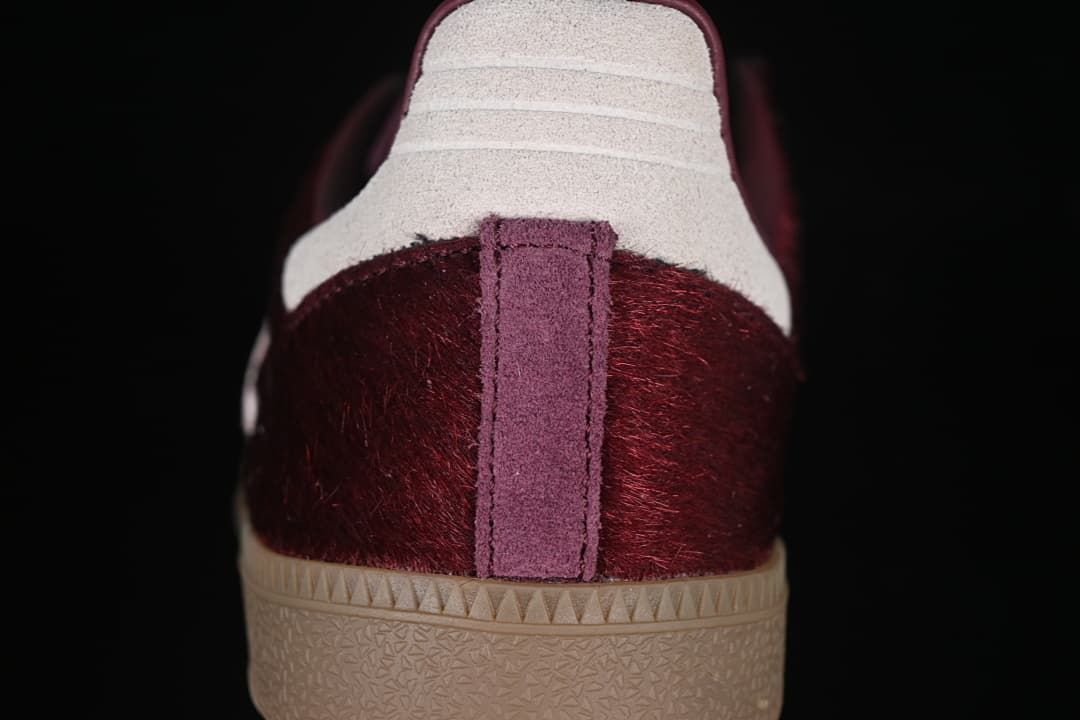 Rear view showing burgundy heel, pale heel panel, and gum outsole