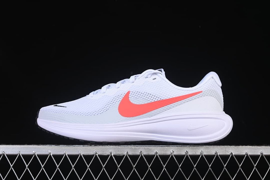 Side profile of the white Nike Revolution 8 running shoe with coral-colored Swoosh